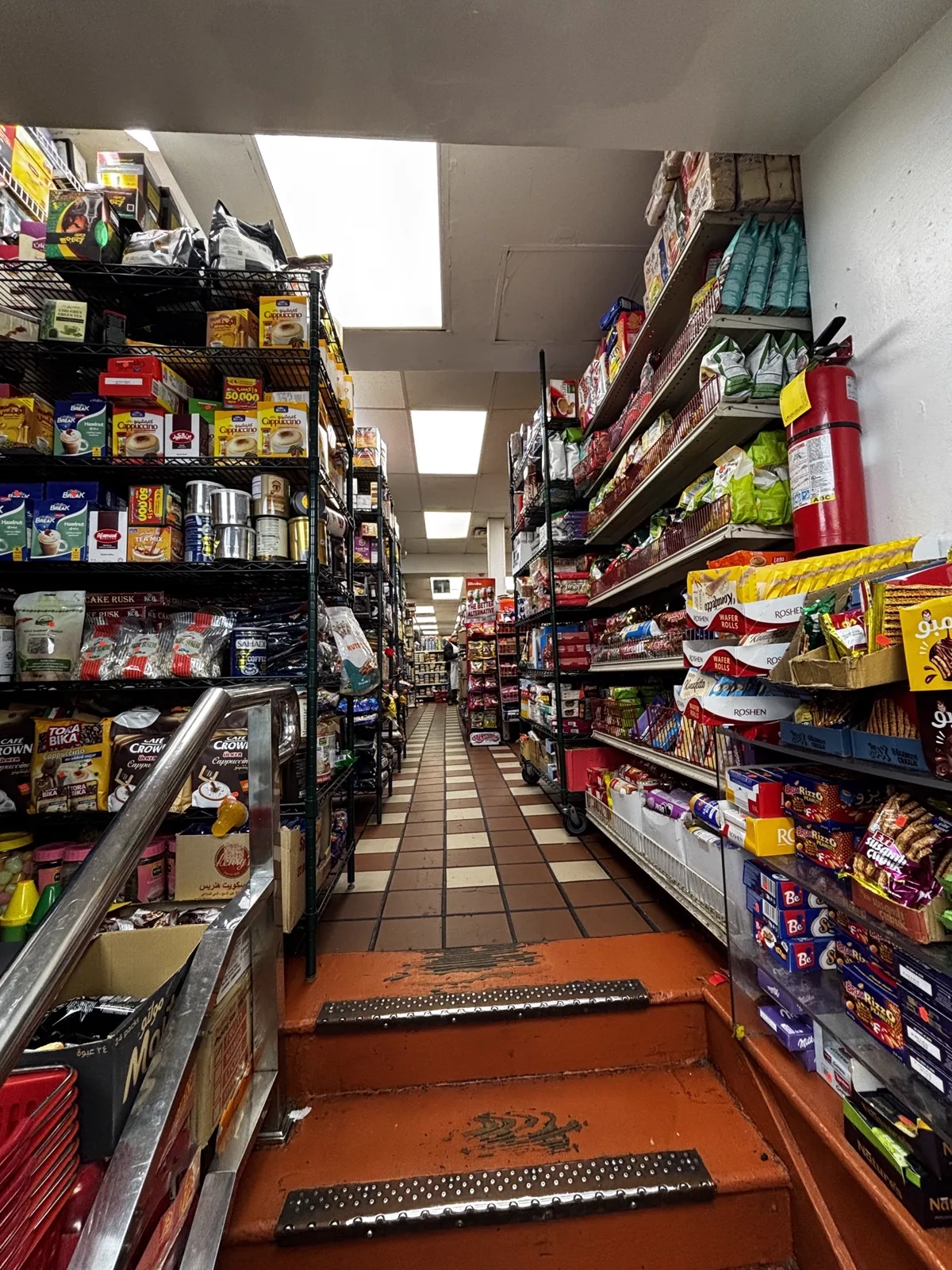 Tile-floored aisle with steps leading down between shelves
