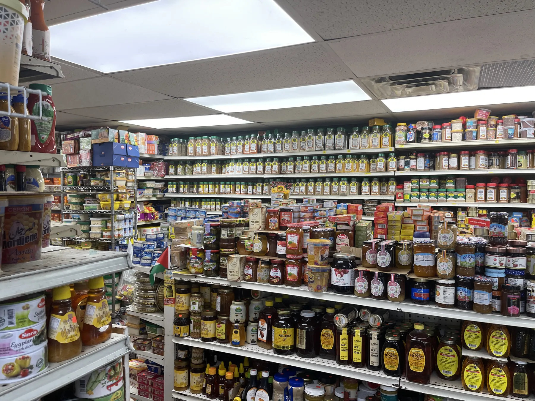 A wall of honeys, jams, olives and preserves at Makkah Market — Middle Eastern grocery store in West Philadelphia