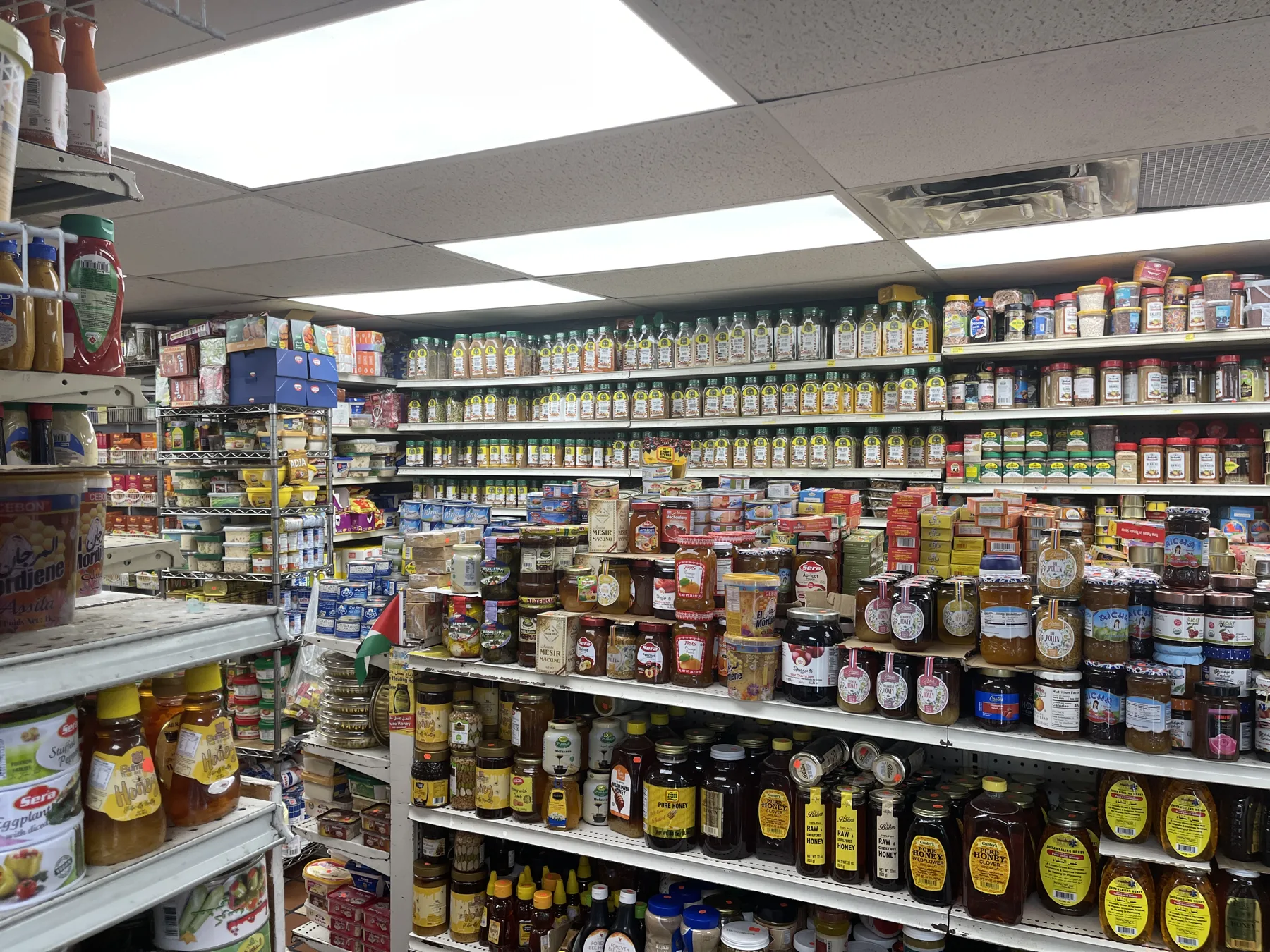 Corner shelves of olive oils, honeys, pickles and preserves at Makkah Market in West Philadelphia