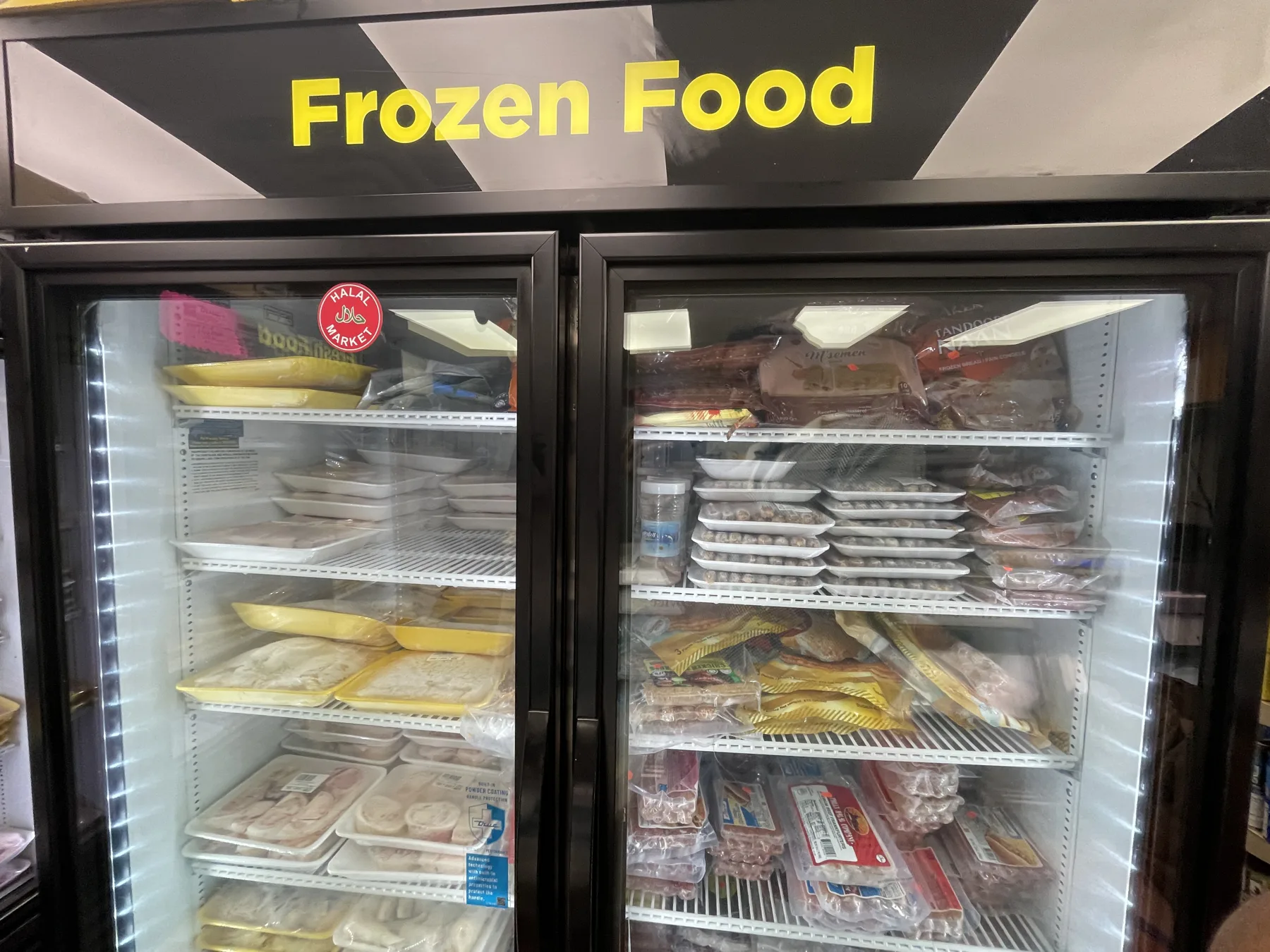 Frozen-food case at Makkah Market — frozen halal cuts, chicken and prepared foods in West Philadelphia